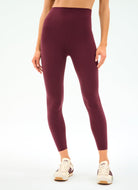Maroon leggings worn by a person on a white background