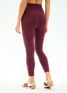 Maroon leggings worn by a person on a white background