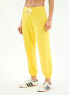 Person wearing bright yellow sweatpants with a white background