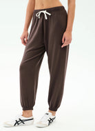 Brown jogger pants with white drawstring on a white background