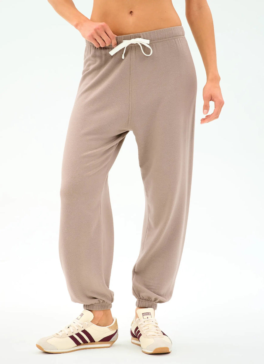 Beige sweatpants worn by a person on a white background