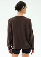 Woman wearing a brown sweatshirt on a white background