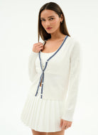 Woman wearing a white dress with a blue ribbon on a white background