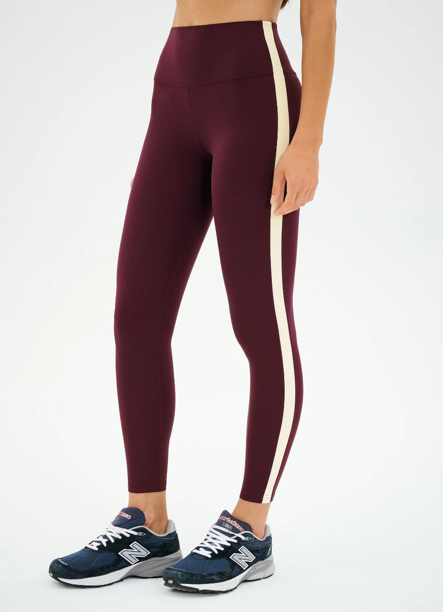 Maroon leggings with a white stripe worn by a person on a white background