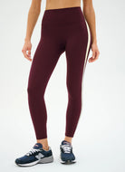 Maroon leggings with white stripes worn by a person on a white background