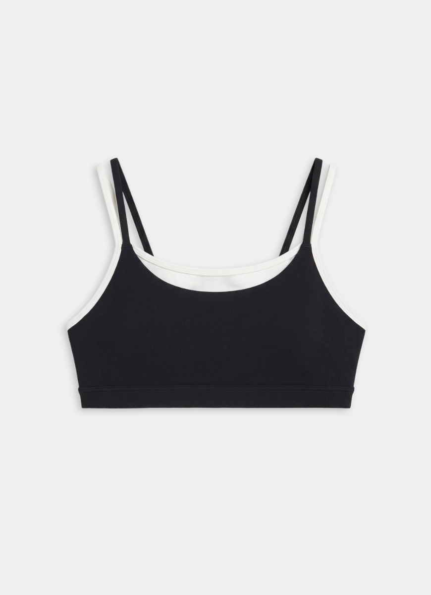 Black sports bra with white straps on a light gray background