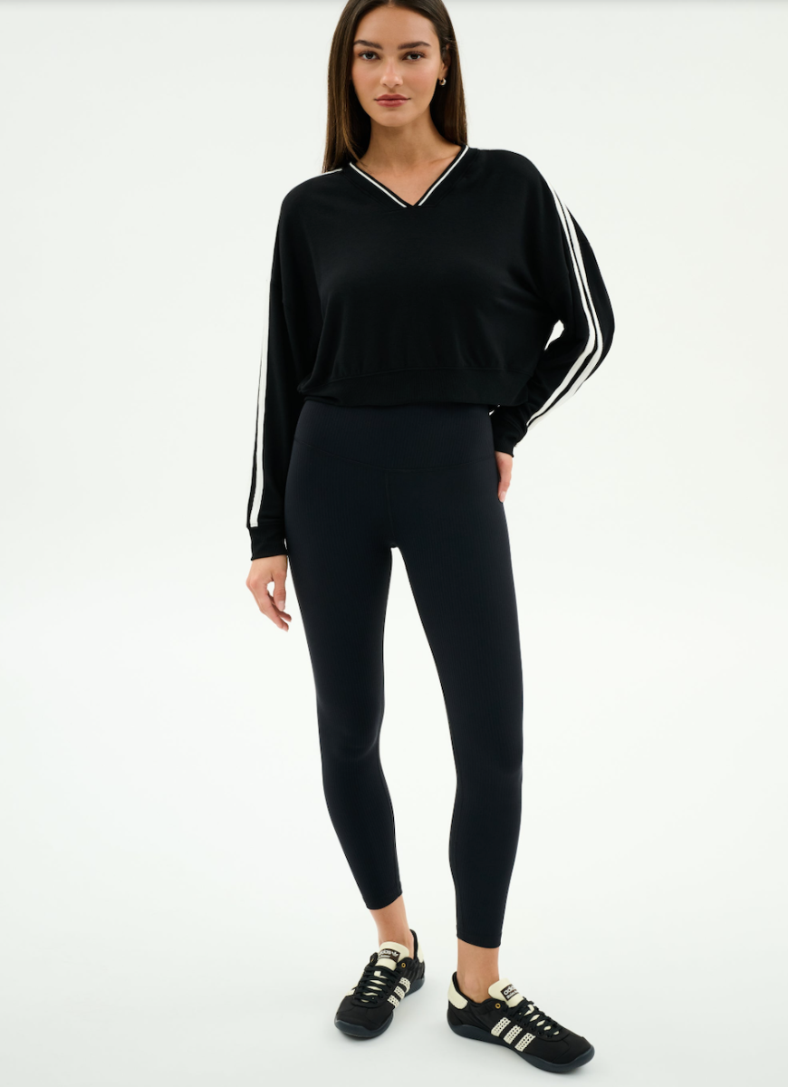 Woman wearing a black outfit with white stripes on a white background
