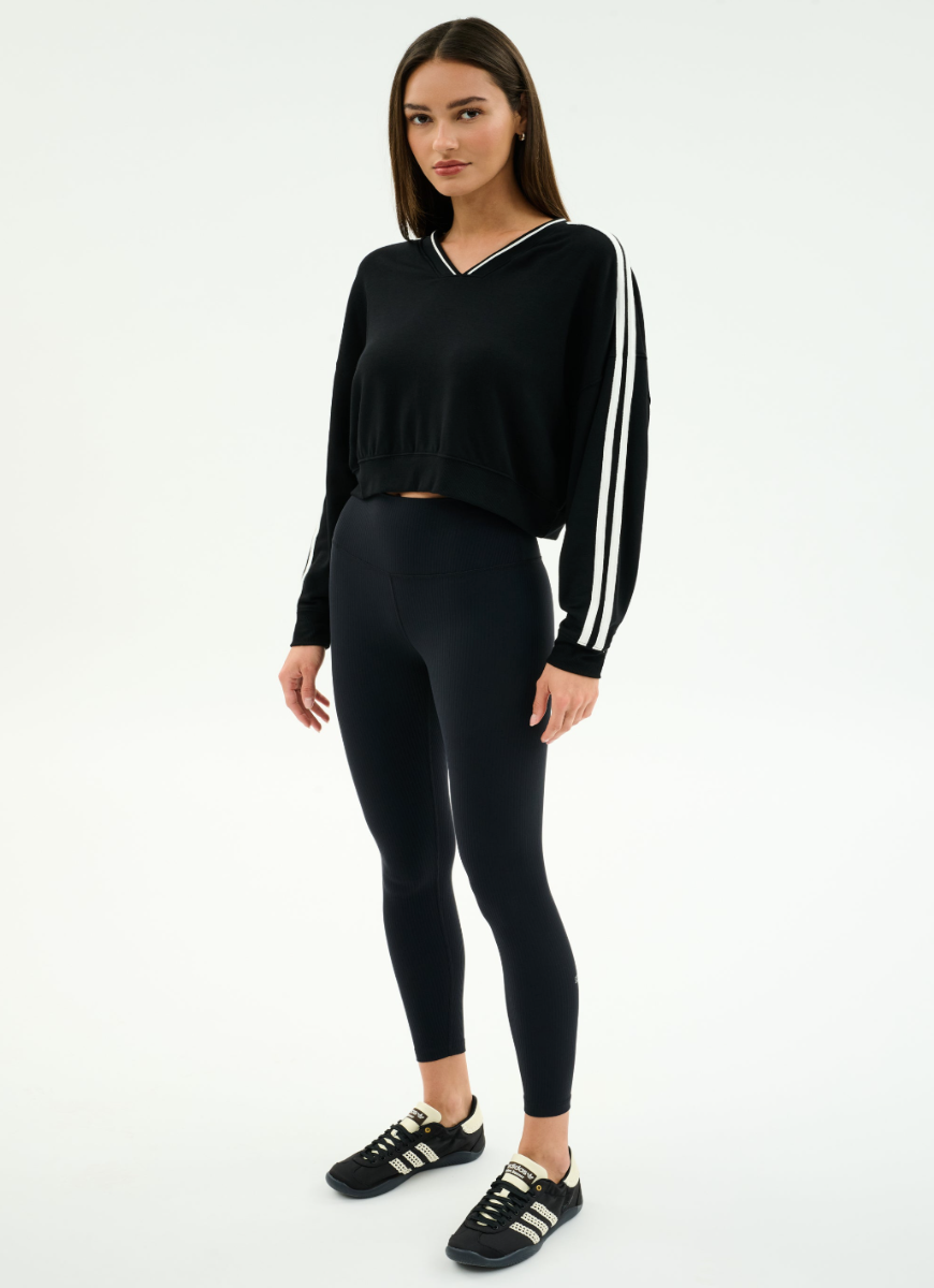 Woman wearing a black outfit with white stripes on a white background