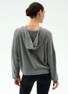 Woman wearing a gray hoodie from behind on a white background