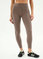 Person wearing brown leggings on a white background