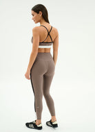 Woman wearing a sports bra and leggings on a white background