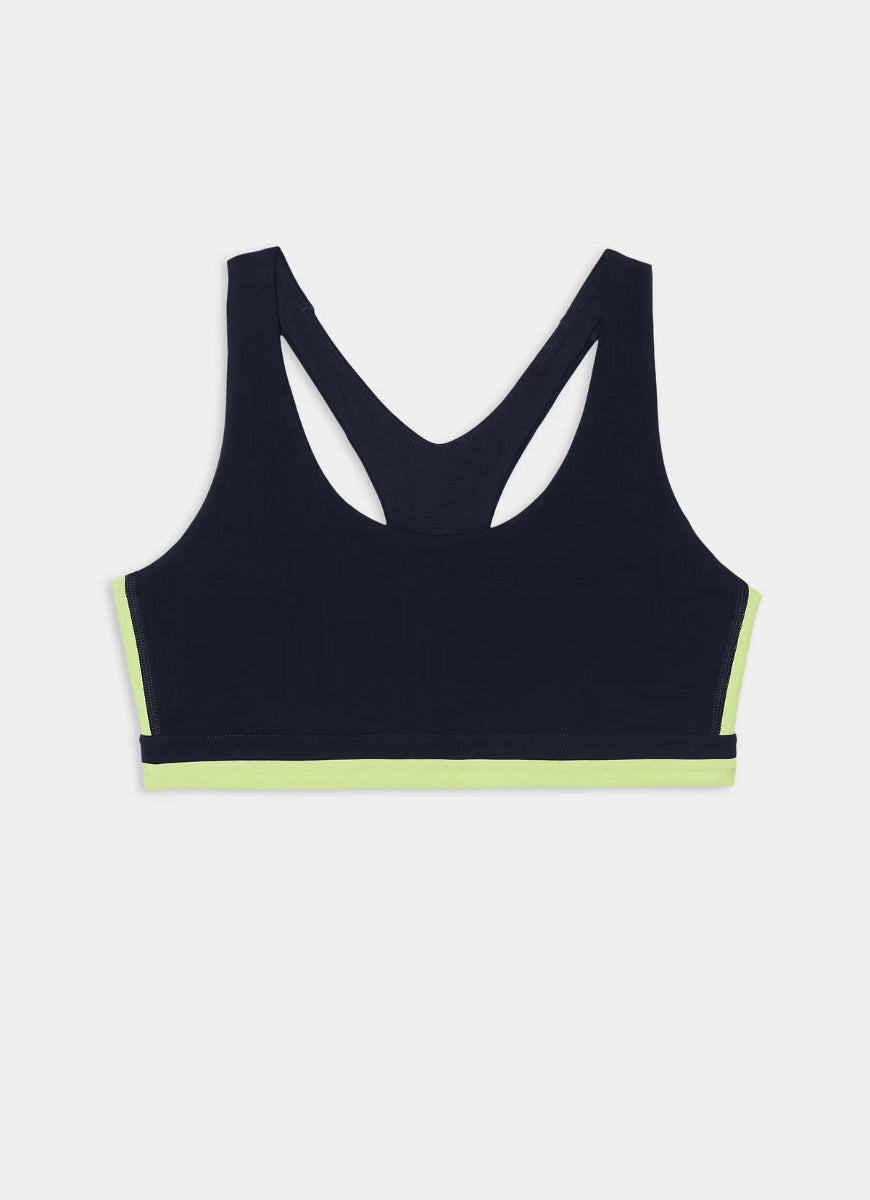 A dark navy blue racerback sports bra with neon yellow-green trim along the underbust and bottom hem, displayed flat against a light gray background.