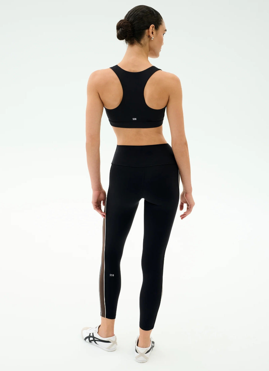 Person wearing black athletic top and leggings on a white background