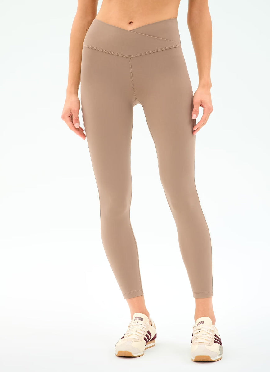 Beige leggings worn by a person on a white background