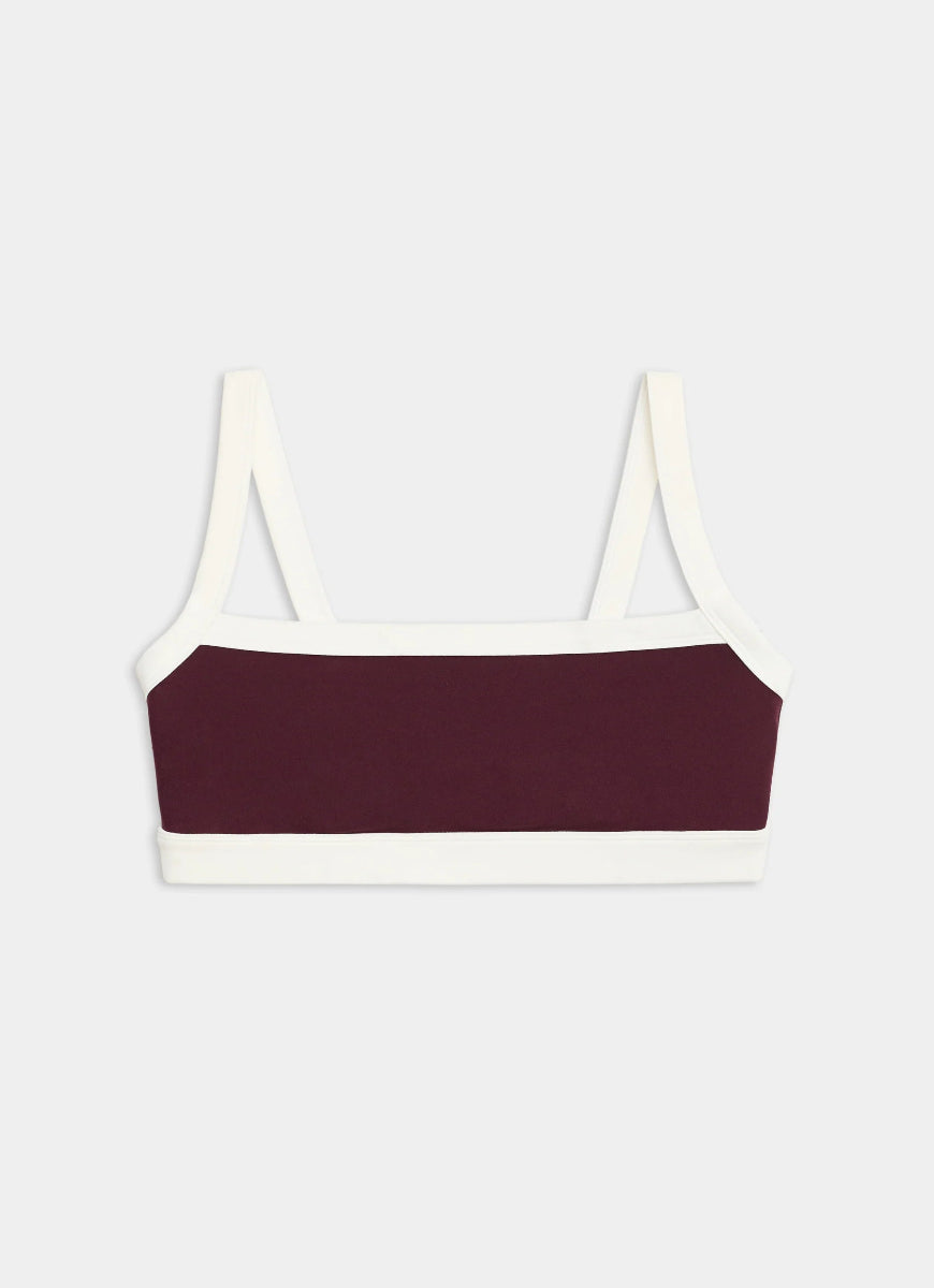 Bralette with white straps and burgundy band on a light gray background