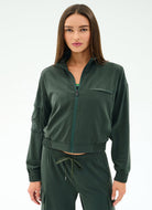 Woman wearing a green tracksuit on a white background