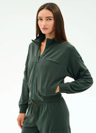 Woman wearing a green tracksuit against a white background
