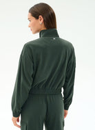 Person wearing a green tracksuit on a white background