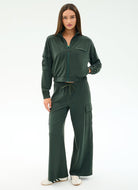Woman wearing a green tracksuit on a white background