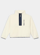 An off-white fleece pullover jacket with a navy blue half-zip collar and a vertical zippered pocket on the chest, displayed against a light gray background.