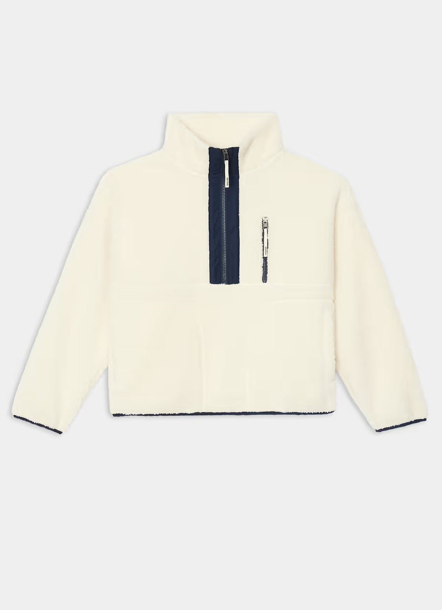 An off-white fleece pullover jacket with a navy blue half-zip collar and a vertical zippered pocket on the chest, displayed against a light gray background.