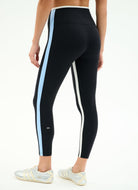 Black leggings with blue and white stripes worn by a person on a white background