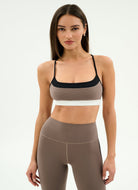 Woman wearing a brown sports bra and leggings set on a white background