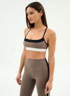 Woman wearing a sports bra and leggings on a white background
