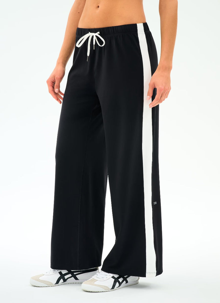 Black wide-leg pants with a white drawstring and side stripe worn by a person on a white background