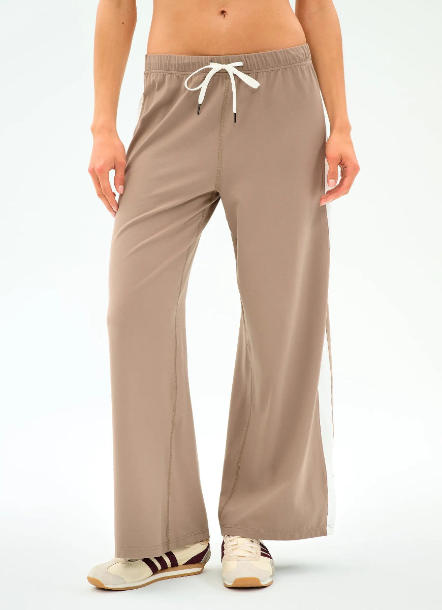 Beige lounge pants worn by a person on a white background