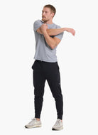 vuori Men's Sunday Performance Jogger in Black Full Model Front View Model Stretching