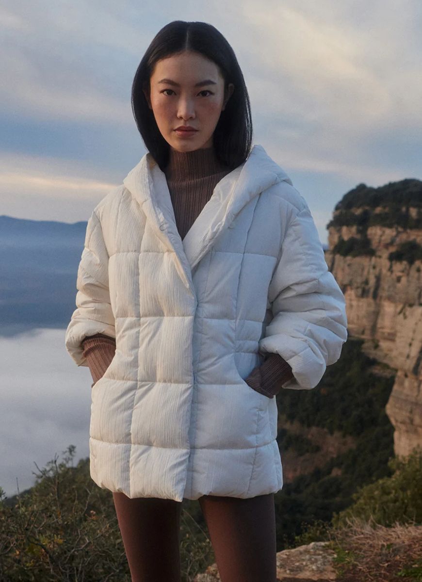 Varley Kaia Quilted Coat in Jet Stream Front View Model With Hands in Pockets