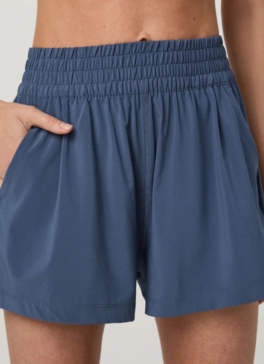 Vuori Women's Villa Short in Azure Close Up Front View With Hand in Pocket