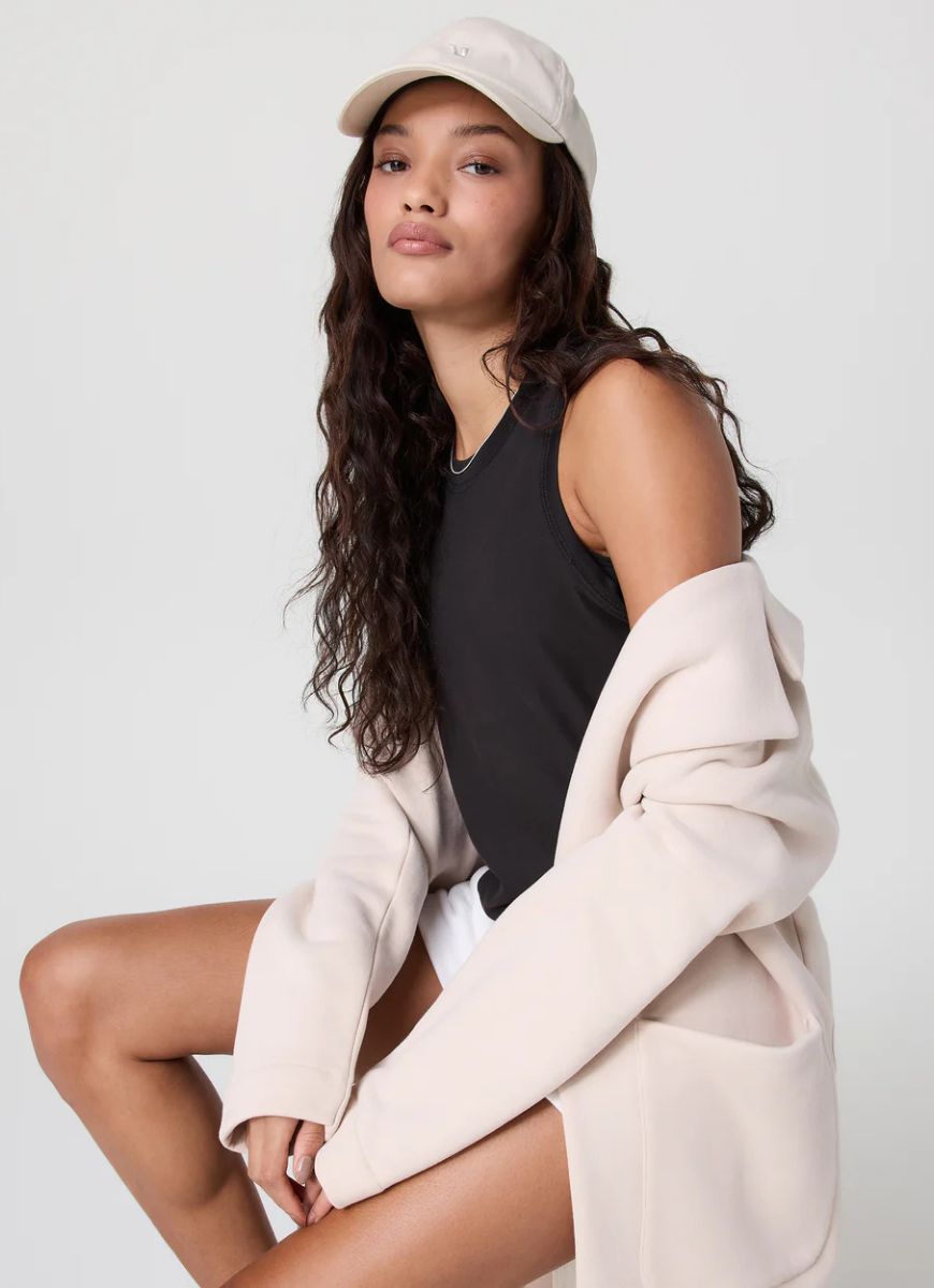Vuori Women's Energy Top in Black Side View With Model Sitting Down