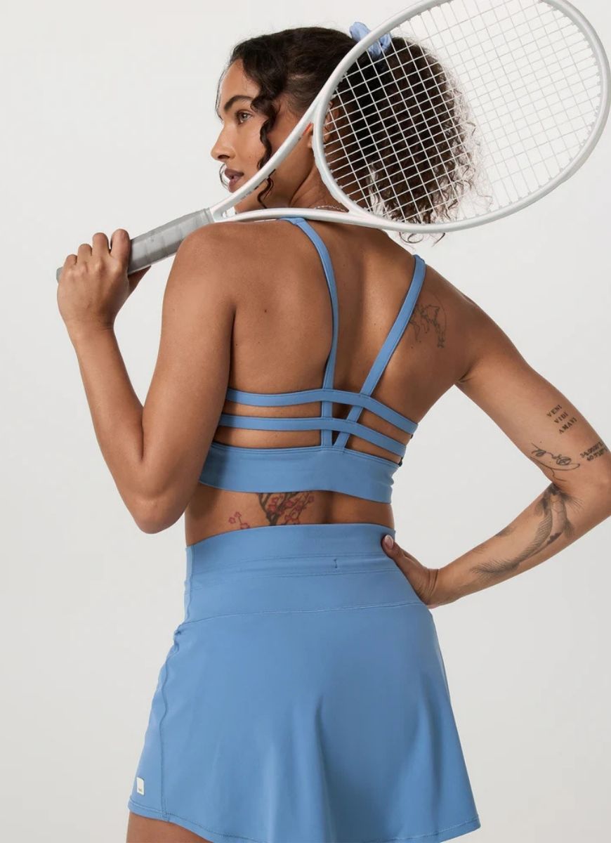 Vuori Yosemite Longline Sports Bra in Light French Blue Back View With Model Holding a Tennis Racquet 