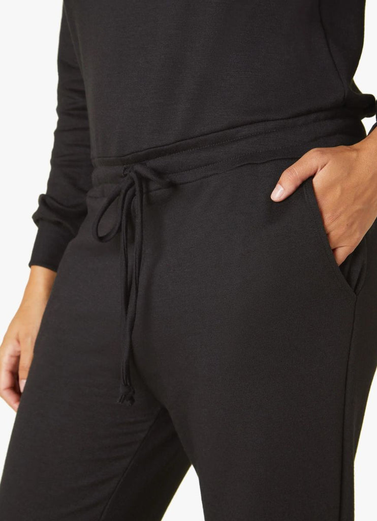 Beyond Yoga Women's Ski Weekend Jumpsuit in Black Close Up Front View with Hand in Pocket