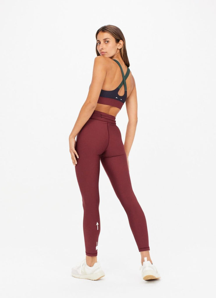 The Upside Women's Matte Tech Midi Pant in Burgundy Full Model Back View