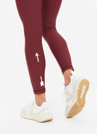 The Upside Women's Matte Tech Midi Pant in Burgundy Close Up Back View of Logo on Legs