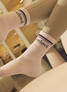 relevé Crew Socks in White with Black Logo Both Feet Up